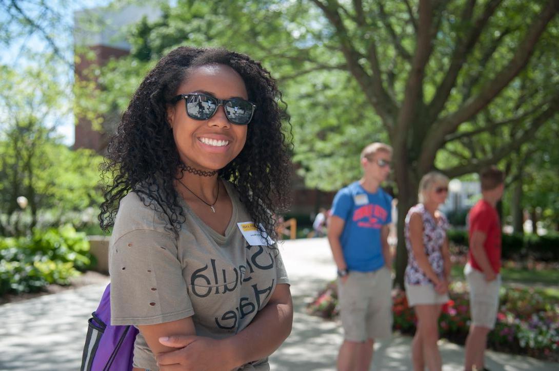 Student on a tour, standing on the Avenue of Eagles